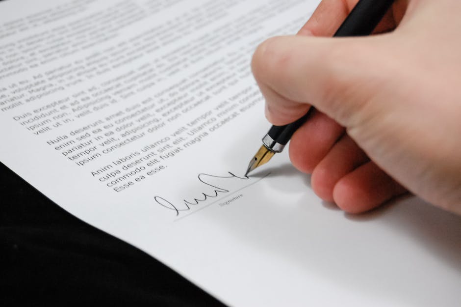 Close-up of a hand signing a legal document with a fountain pen